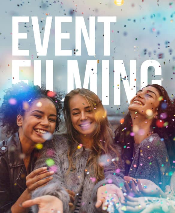 A group of women smiling with confetti flying around them. The text in the background says 'Event Filming'