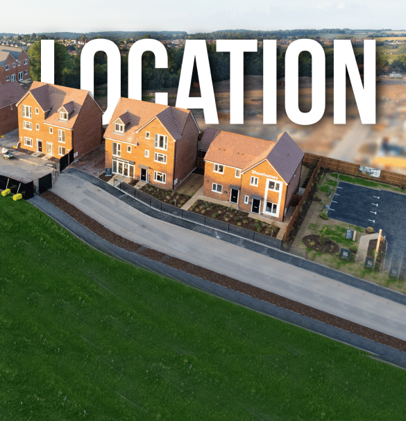 Aerial view of a housing development with several newly constructed brick houses. The word "LOCATION" in large white letters overlays the image. The foreground shows a green field, while the background includes construction and a distant landscape. Ideal for showcasing video production services.