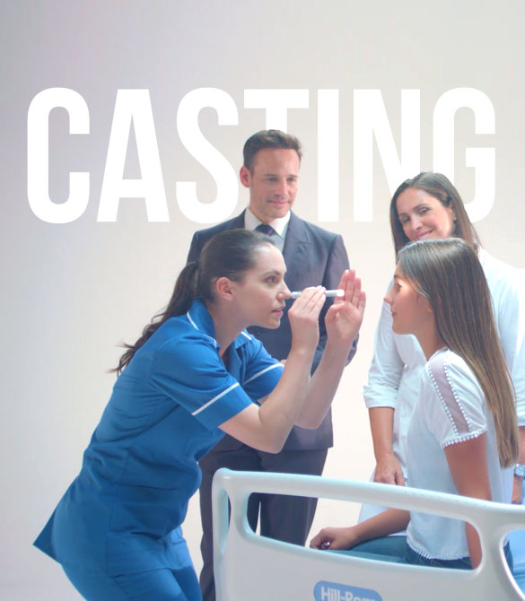A nurse is examining a young female patient's face while she sits on a hospital bed. Two adults stand behind them, observing the interaction. The word "CASTING" is in large white letters at the top of the image, hinting at an NHS promotional video in progress.