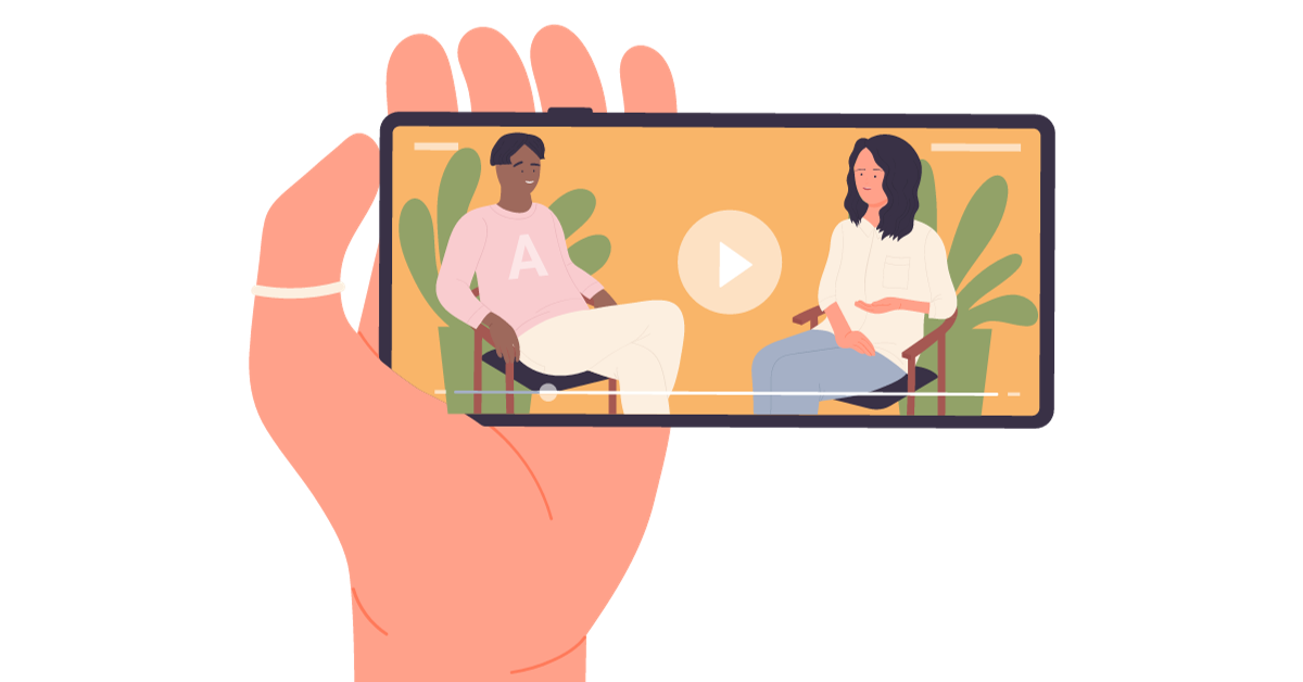 A Hand Holding A Smartphone Displays A Video Of Two People Sitting On Chairs And Talking. The Person On The Left Wears A Pink Sweater With An &Quot;A&Quot; On It, And The Person On The Right Wears A White Shirt. Green Plants Are In The Background, Reflecting 2024'S Video Content Trends, With A Play Button Visible. A hand holding a smartphone displays a video of two people sitting on chairs and talking. The person on the left wears a pink sweater with an "A" on it, and the person on the right wears a white shirt. Green plants are in the background, reflecting 2024's video content trends, with a play button visible.
